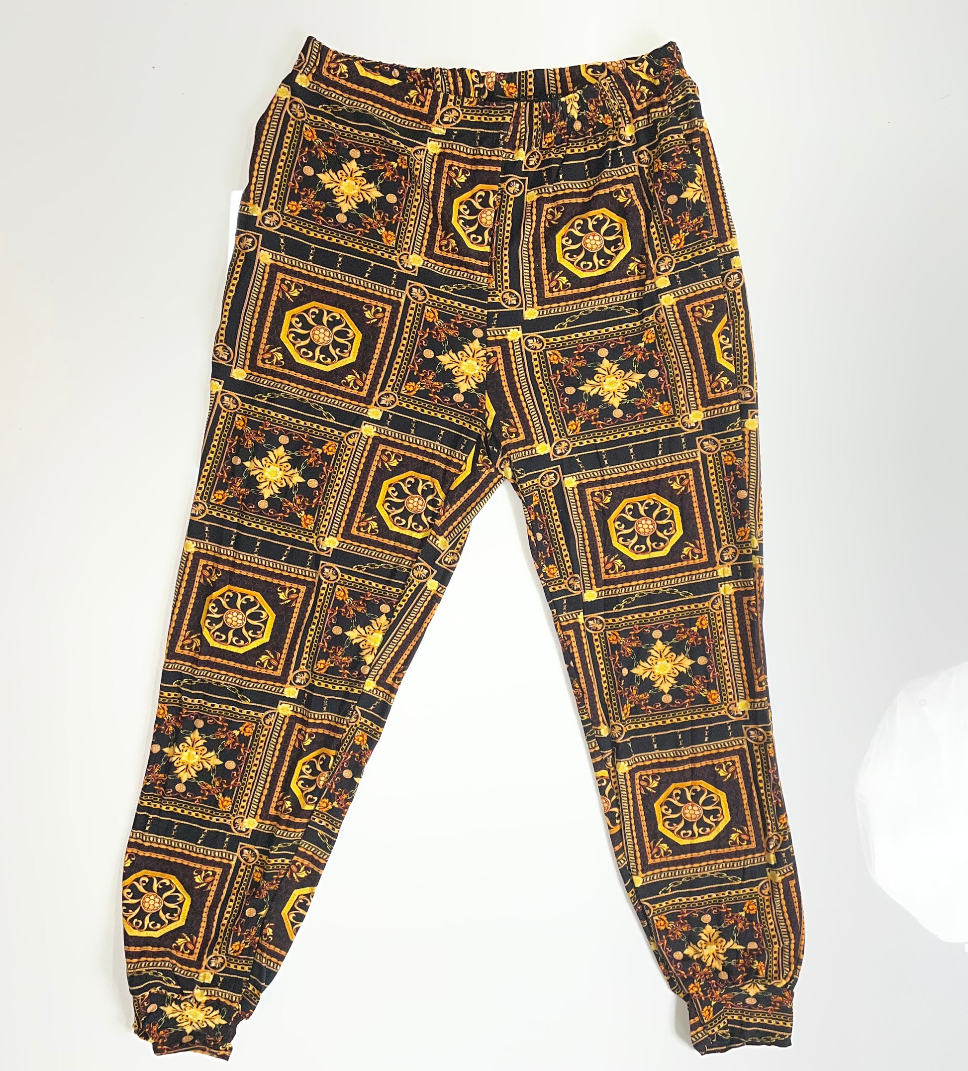 Black and gold patterned pants on a white background
